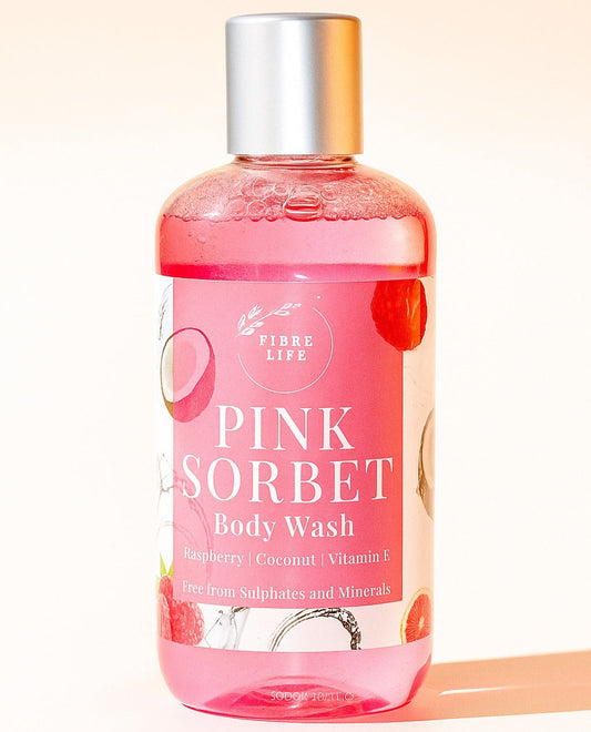 Pink sorbet coconut, vitamin e and raspberry body wash bottle with a white background